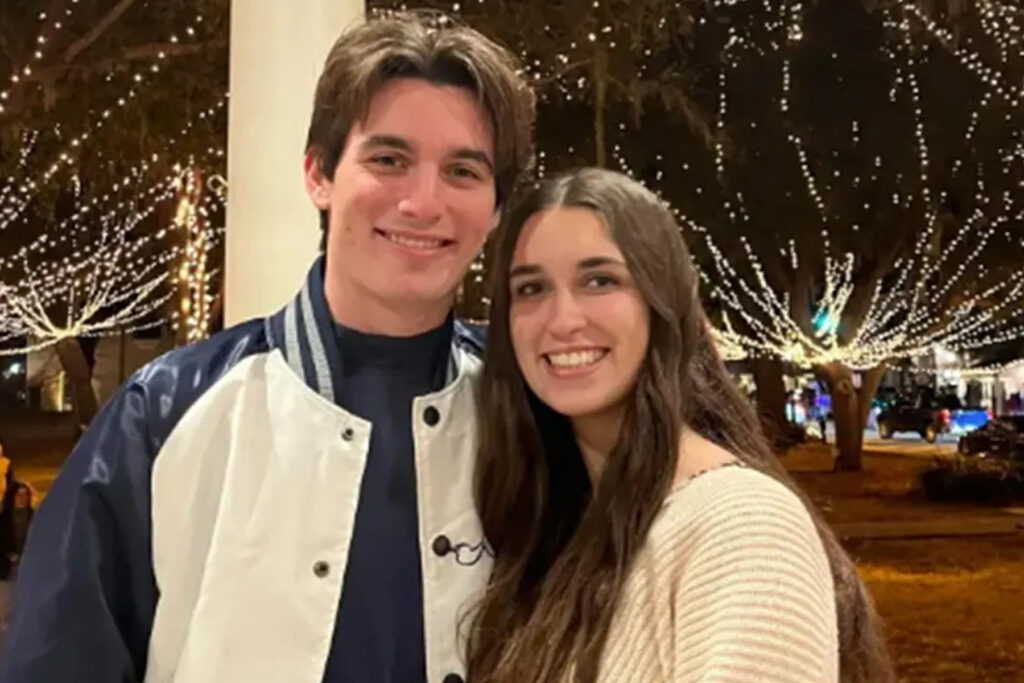 Couple poses at night together.