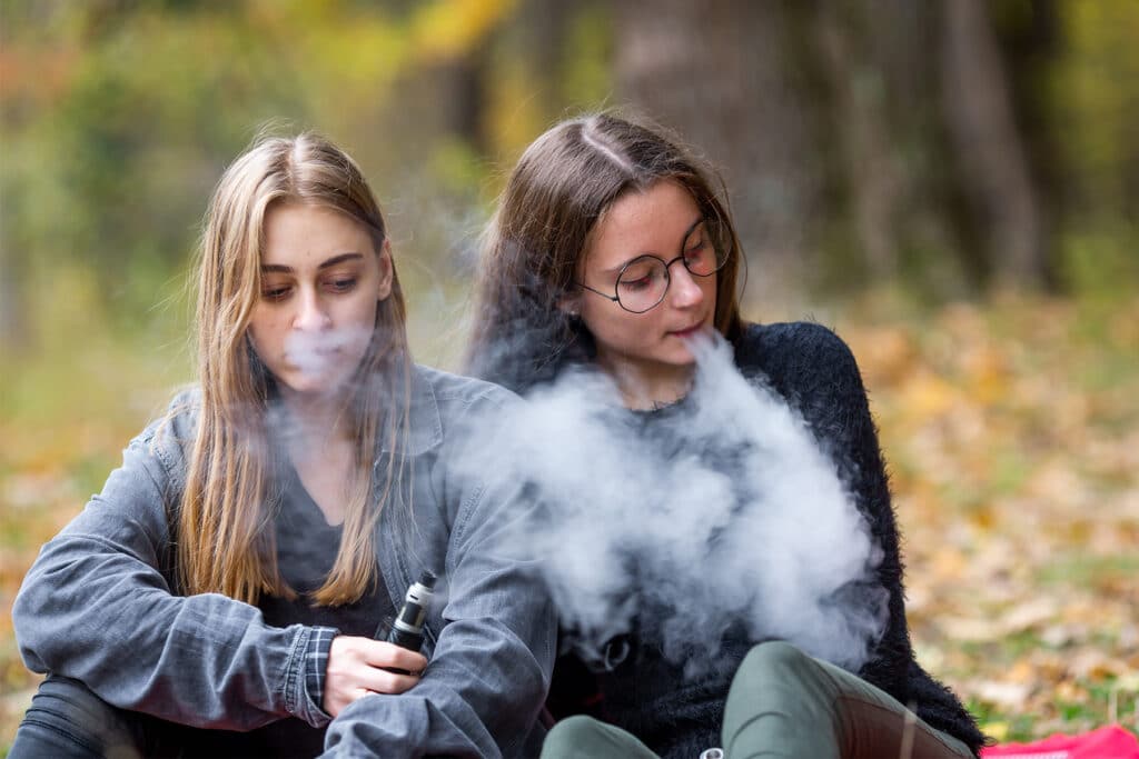 Two teen girls vaping.