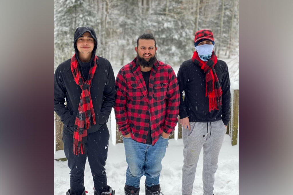 Nicolas Scimone with his three brothers posing outside in the snow.