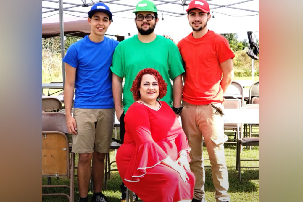 Mom in red poses with her three sons.