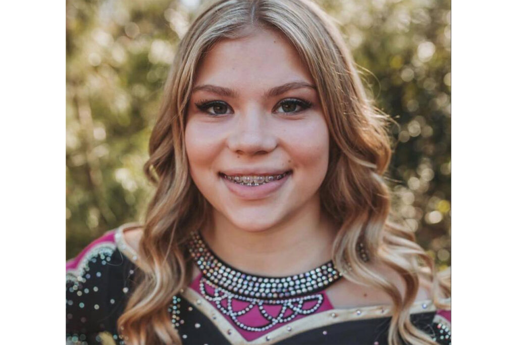 Tristyn Bailey smiling and wearing a cheerleading costume.