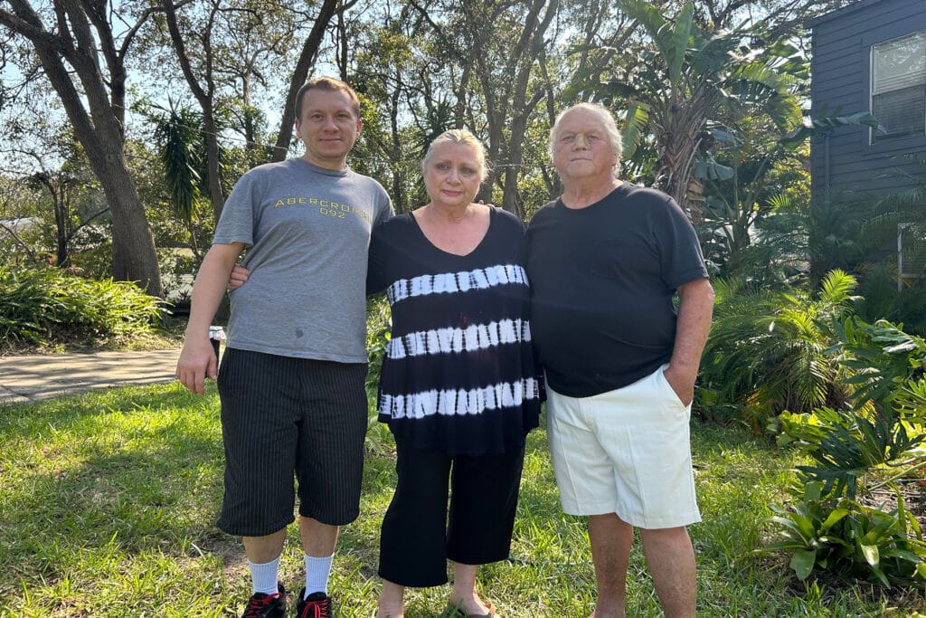 A St. Augustine couple and their son stand outside in the sun.