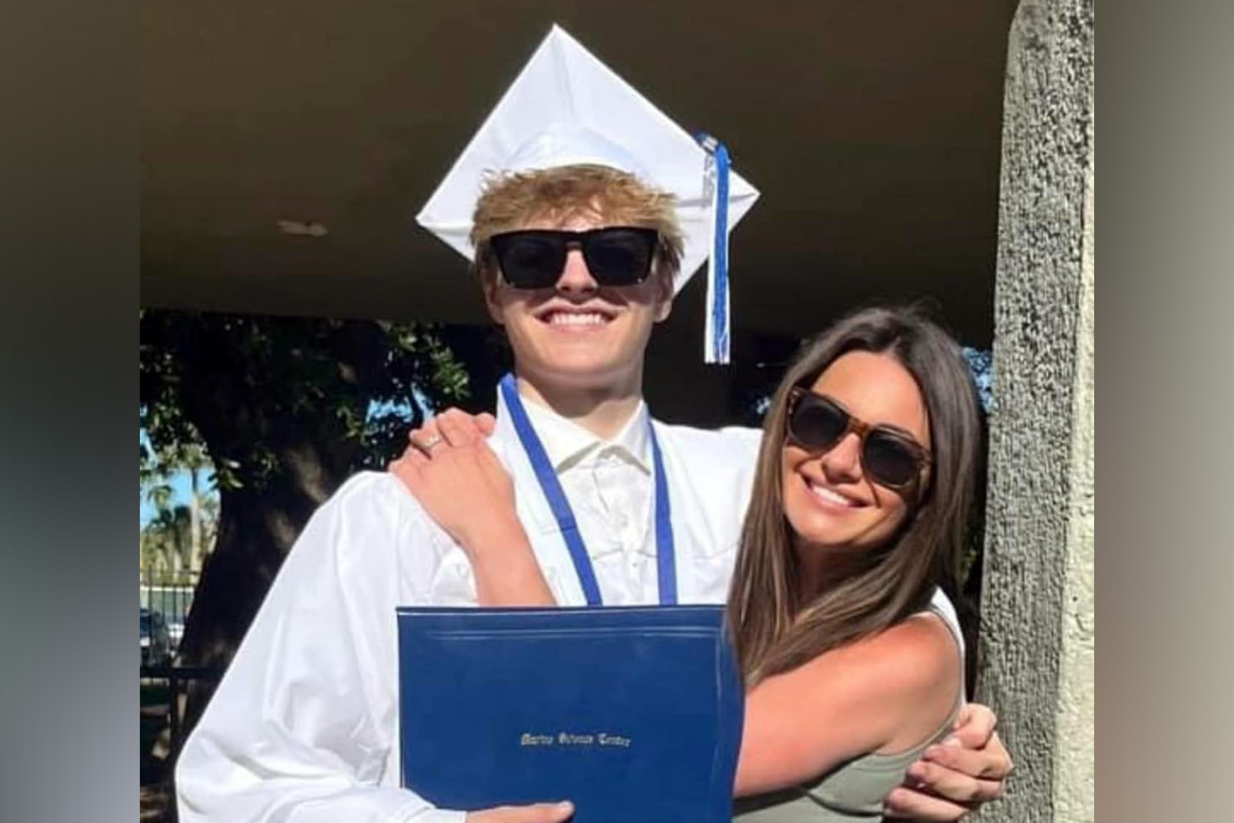 Man in white hat and cape at his high school graduation.