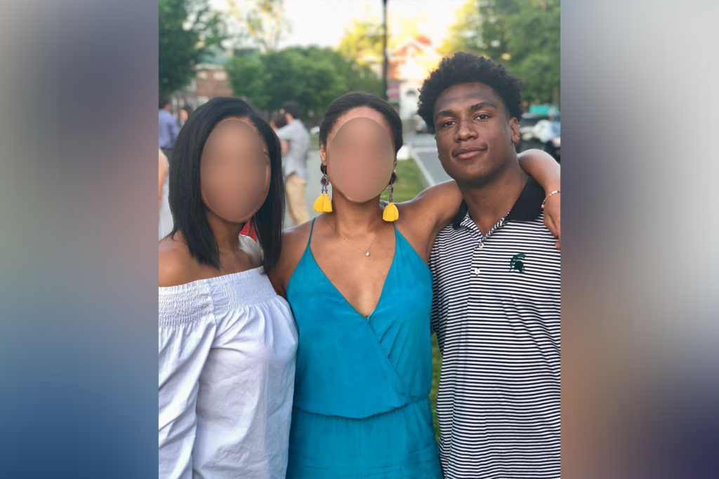 Man poses with two women. 