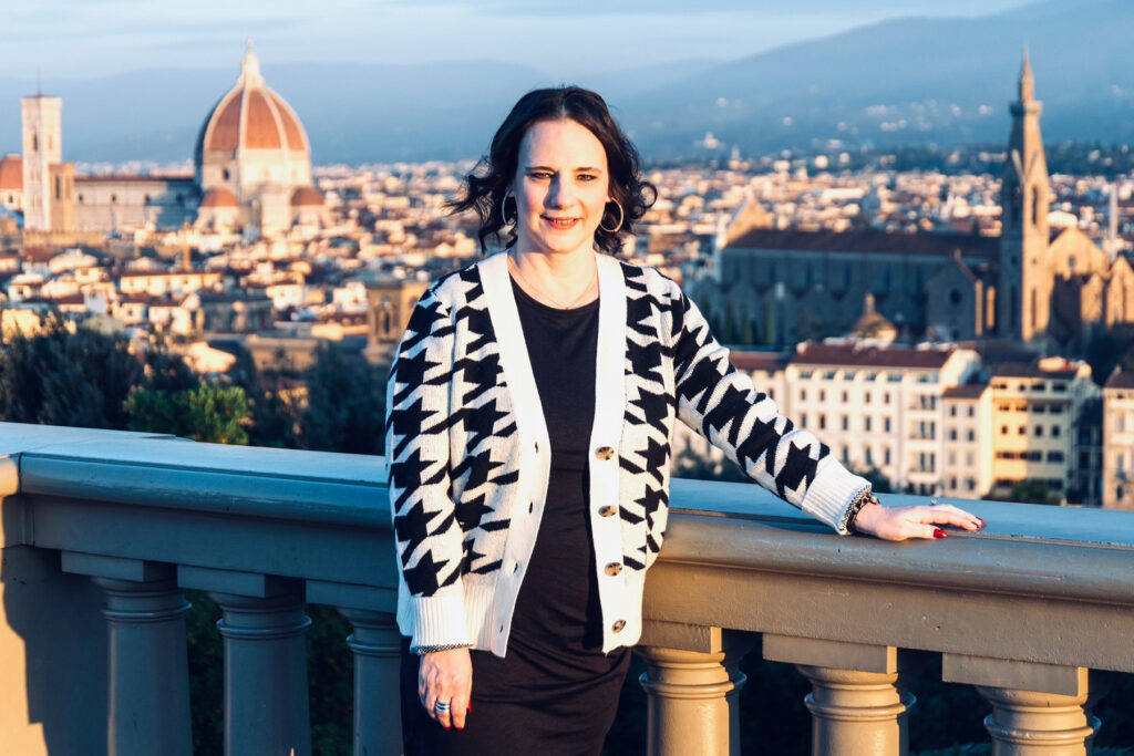 Woman in black and white poses on a balcony in Florence.