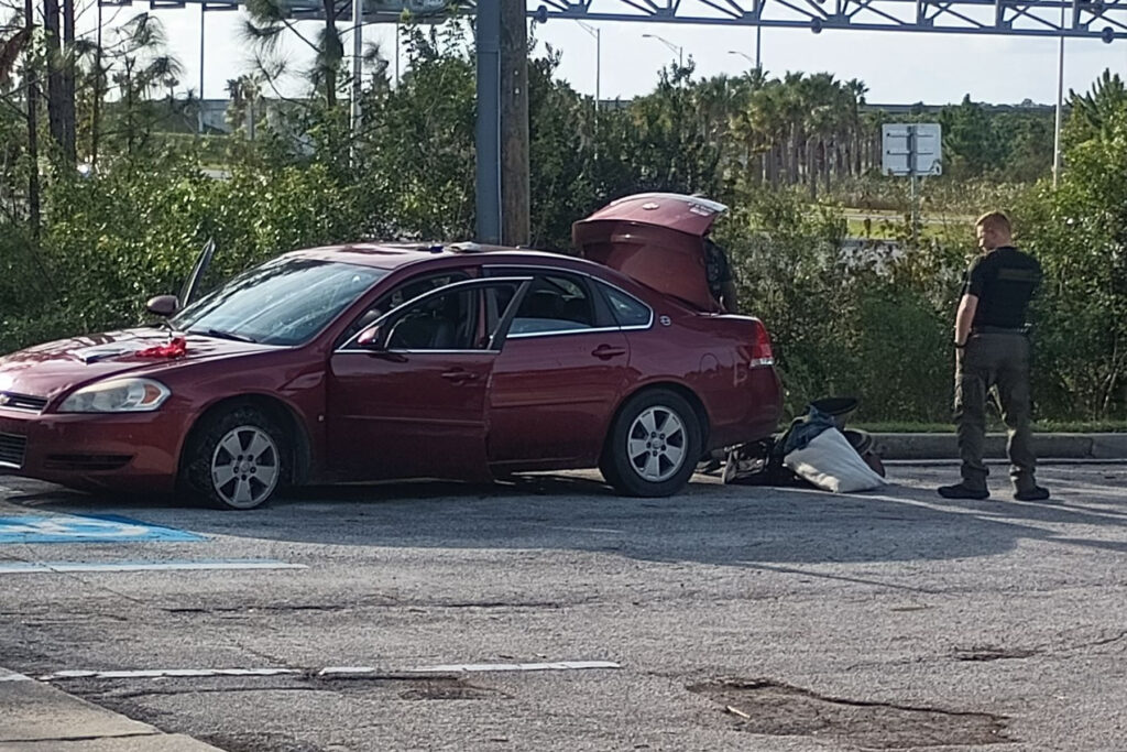 Red Chevrolet Malibu with a flat tire.