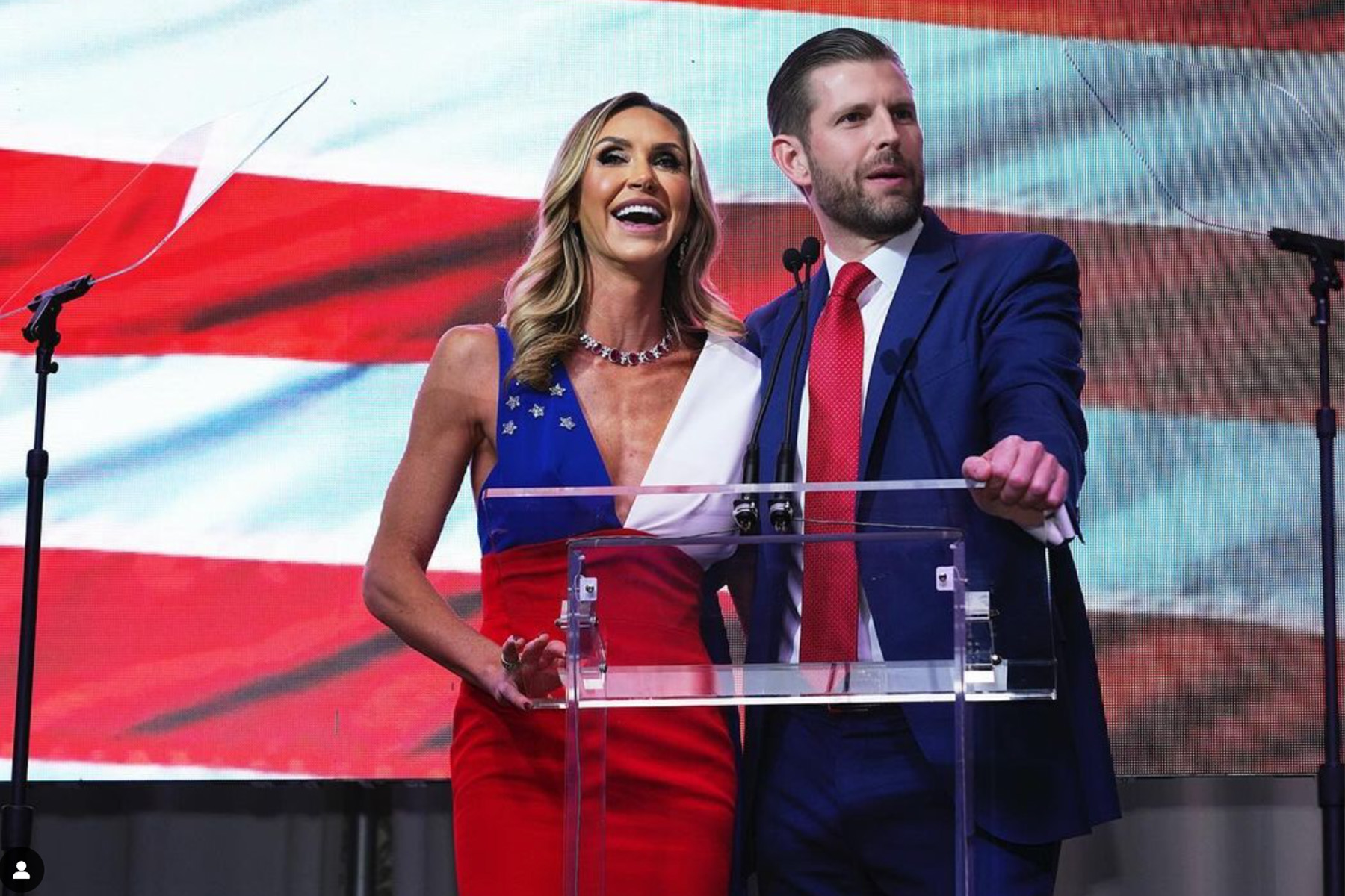 Eric Trump with his wife, Lara Trump in front of an American flag.