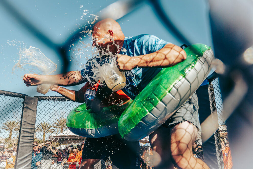 Men wearing  floaties throwing liquid.