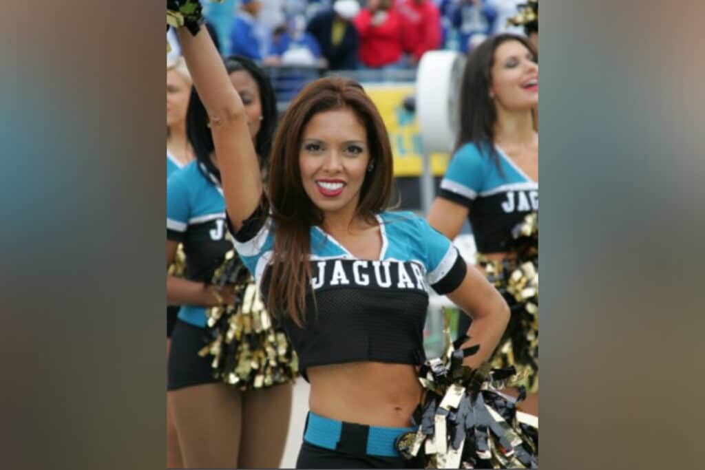 Jaguar cheerleader holding her pom pom in the air