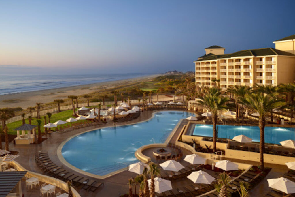 Hotel overlooking a pool and the ocean.