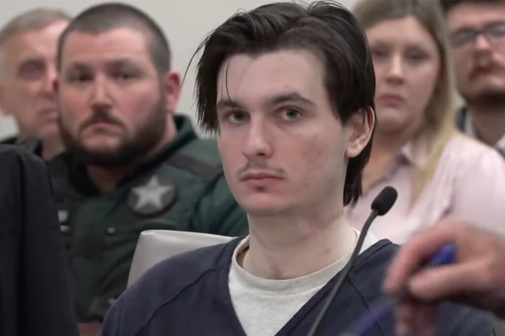 Man looks into camera in courtroom.