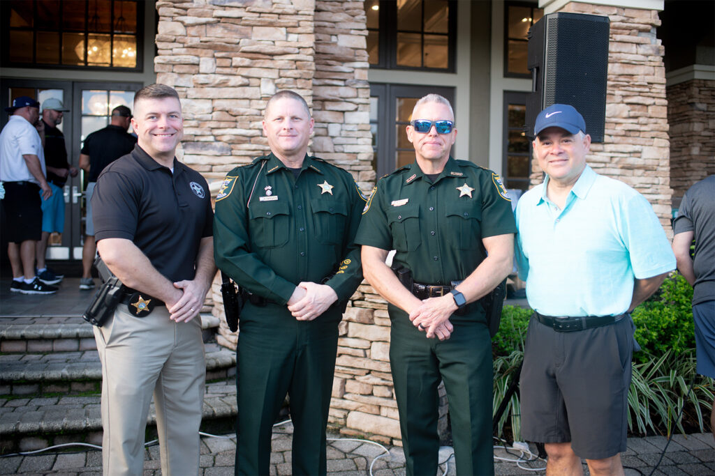 Four men pose for a photo.