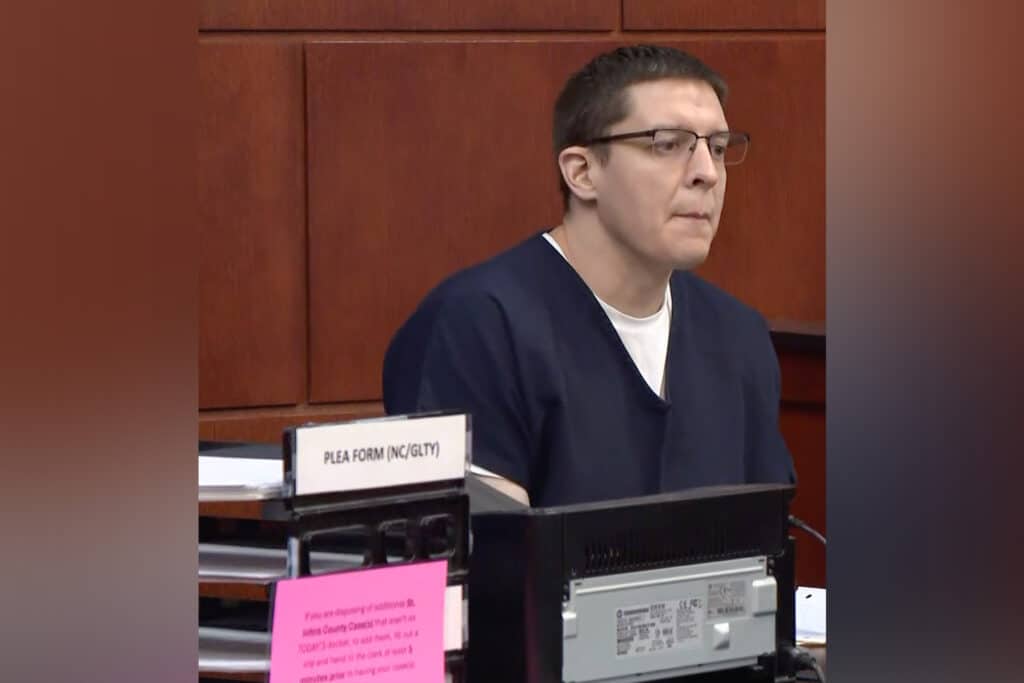 Man in witness box in a courtroom.