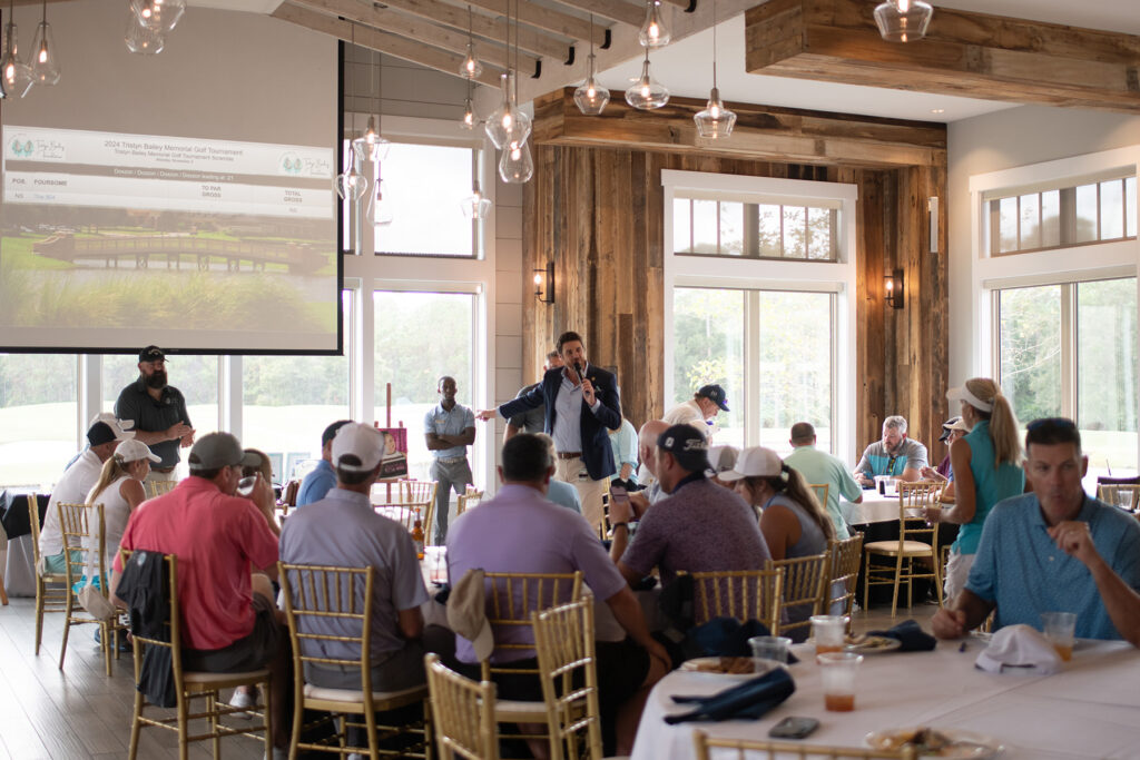 man speaking in front of a crowd.