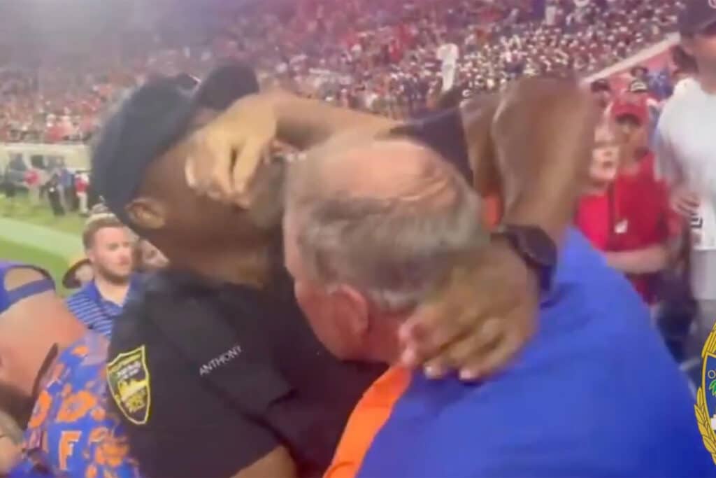 Gator fan shown with his hand over a cop's face.