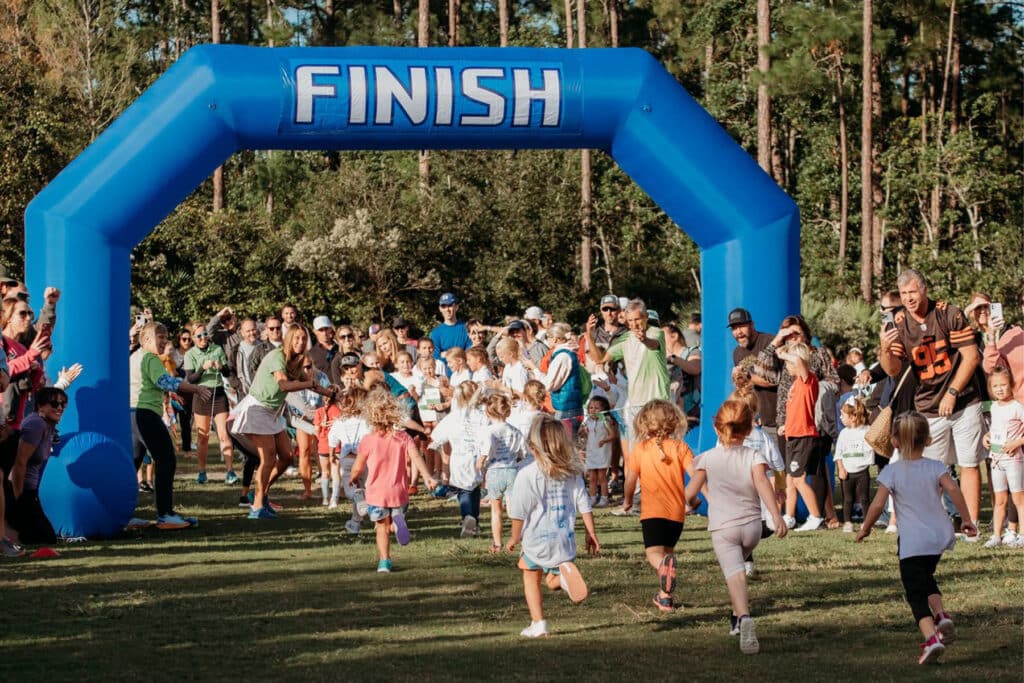 Photo of children running through a finish line.