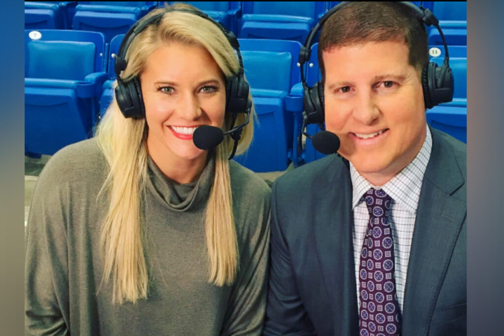 Woman and man wearing headphones at a stadium.