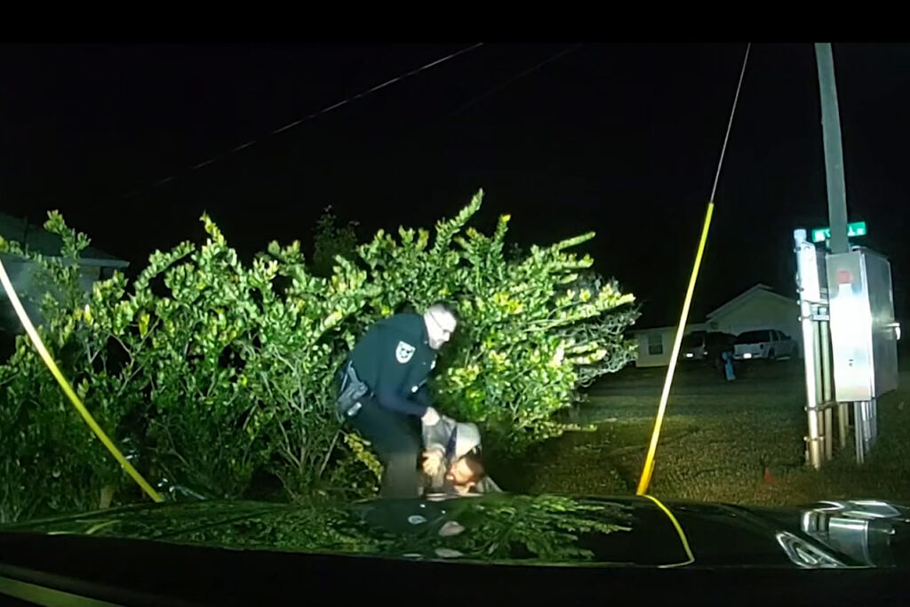 Man shown getting arrested at night.