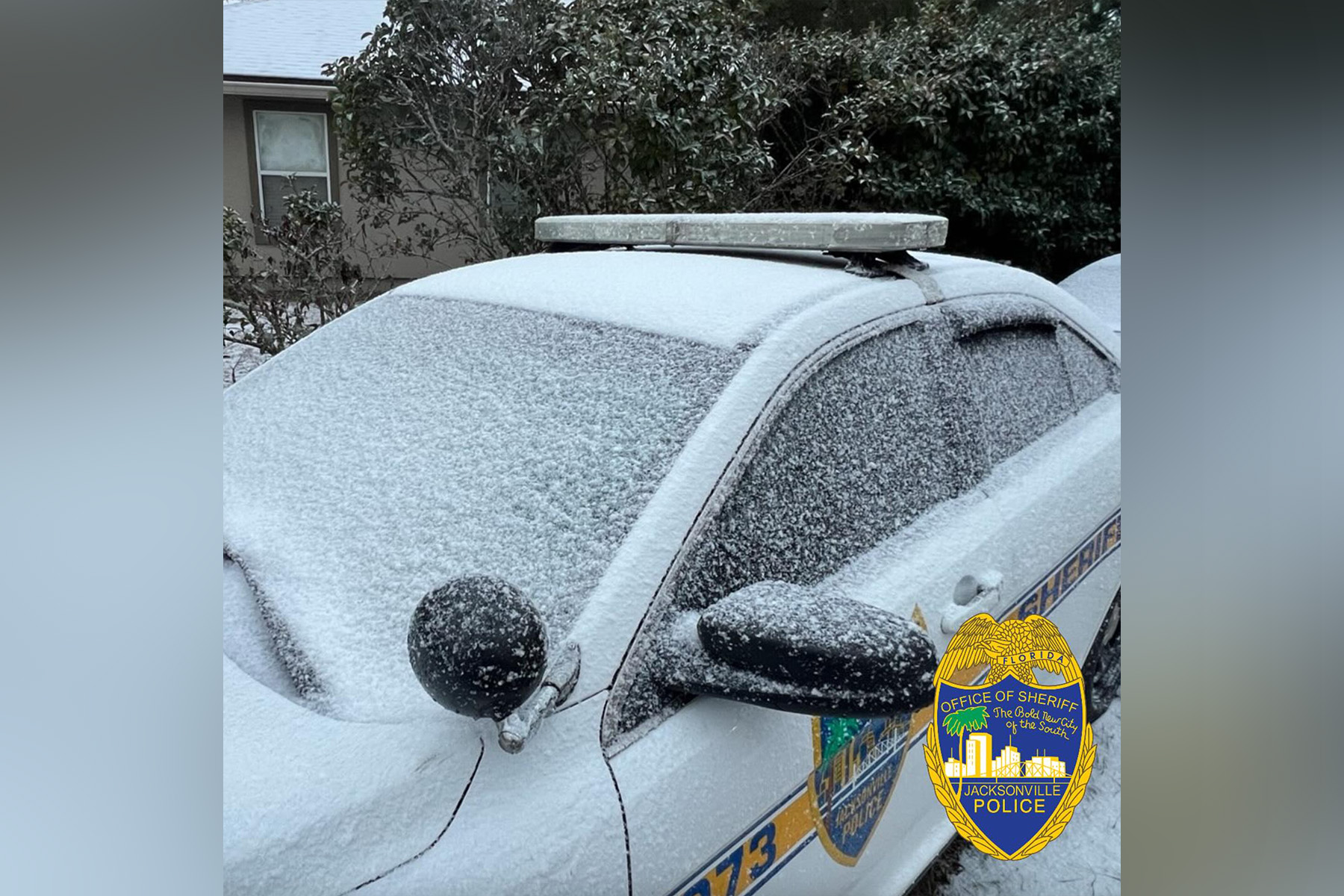 picture of a snow covered police car.