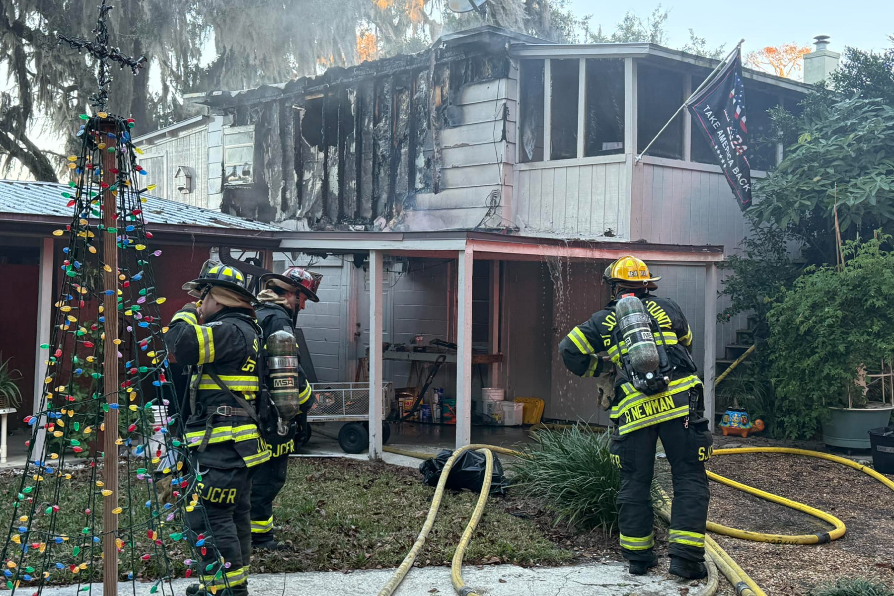 picture of firefighters in front of a home