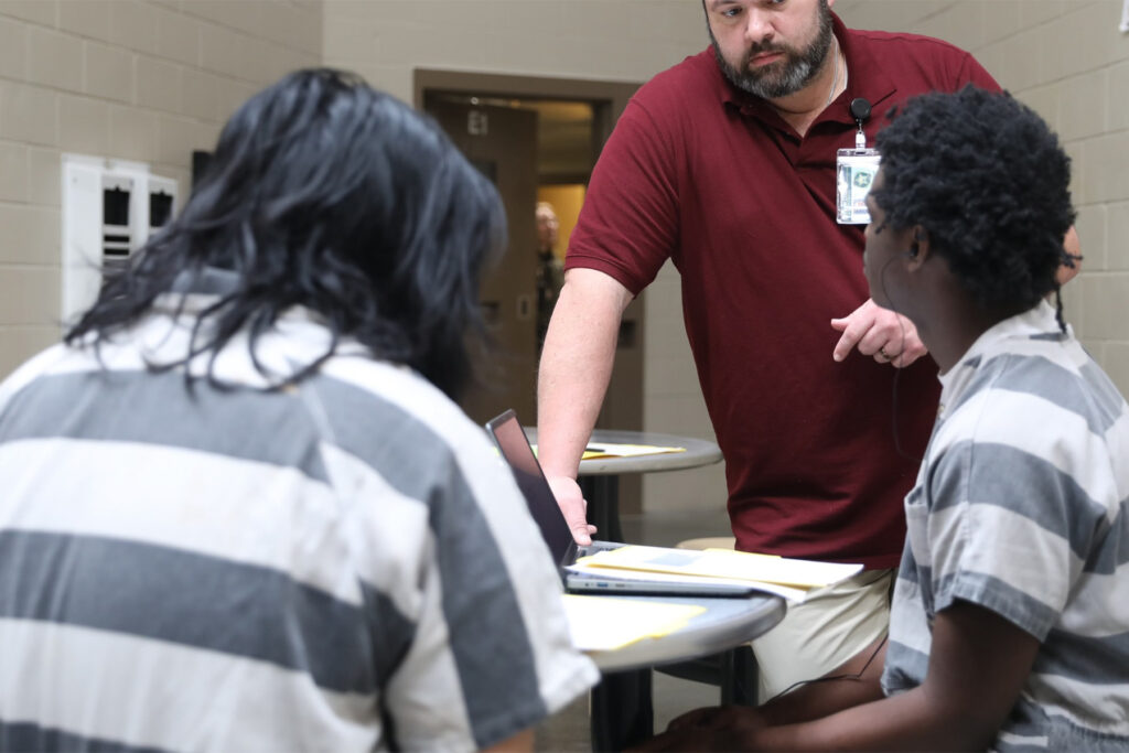 Picture of a teacher teaching class in a jail.