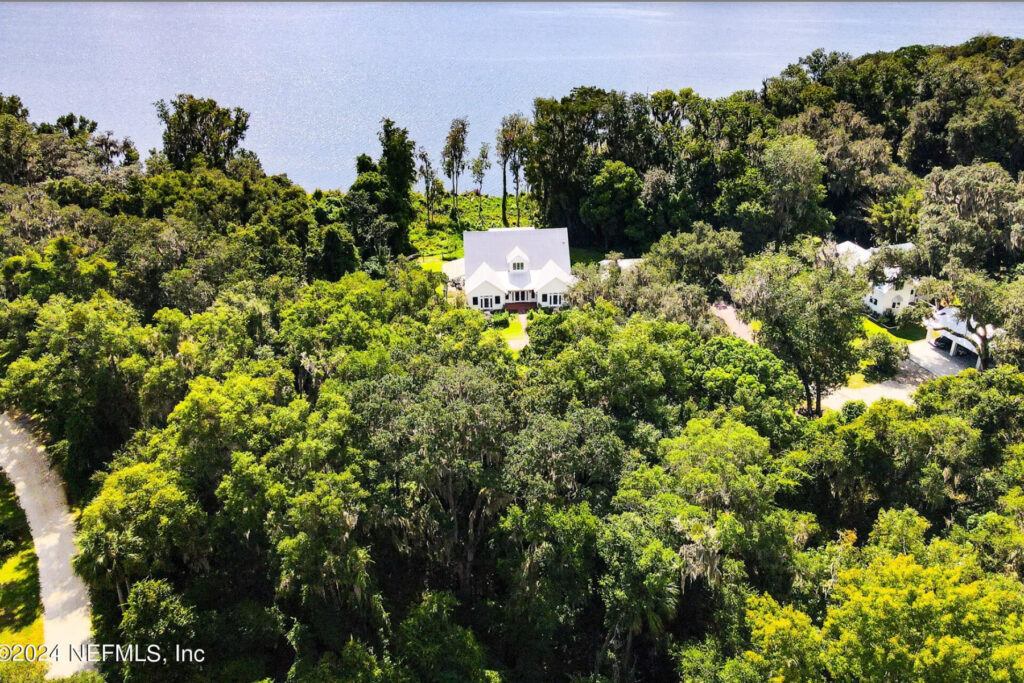 Aerial view of a white Palatka house in the woods on the St. Johns River. River