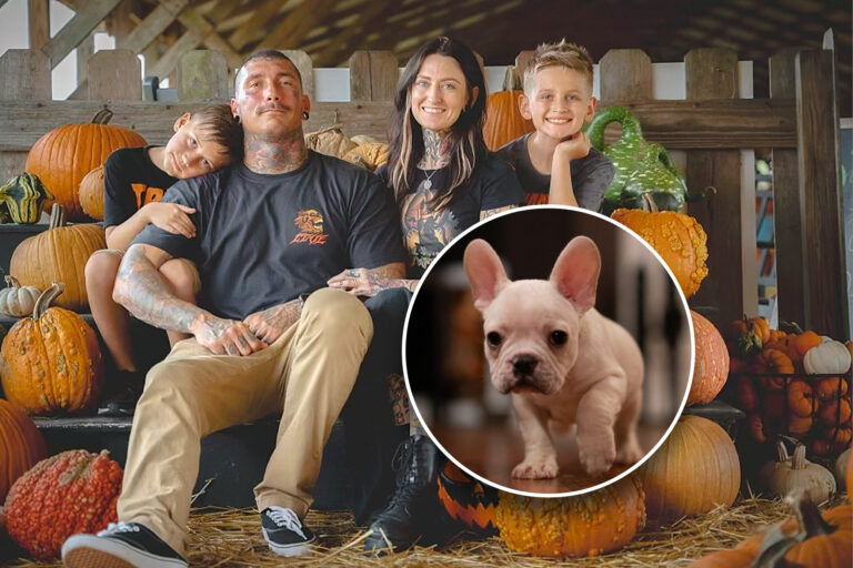 Couple with two sons surrounded by orange pumpkins.