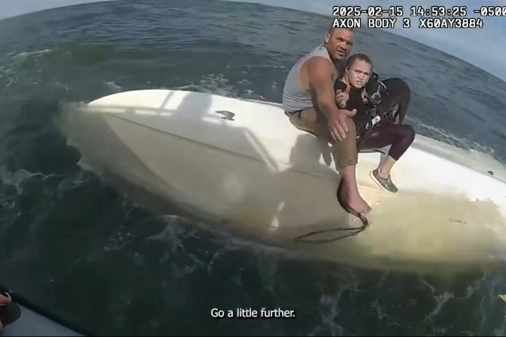 A couple and a dog on top of an overturned boat.