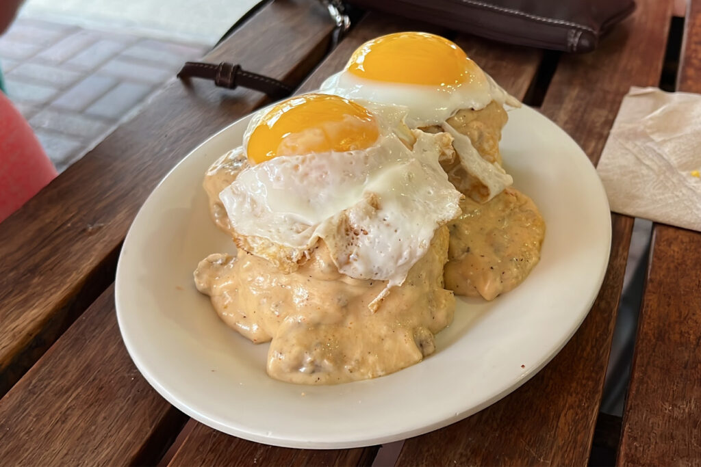 Fried eggs over biscuits smother in gravy.