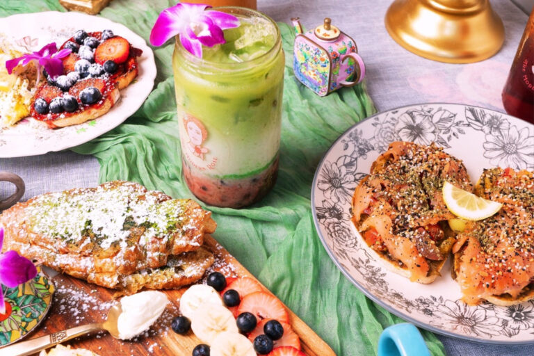 Green and white drink surrounded by plates of breakfast foods.