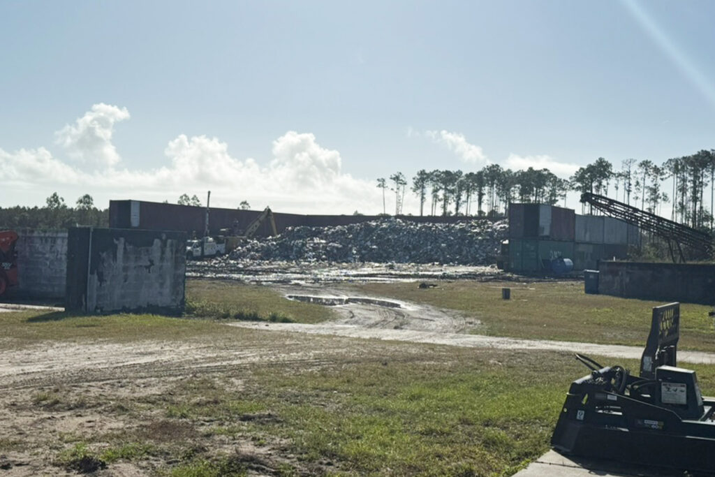 Indianhead Biomass services' treatment site showing shipping containers and trash. 