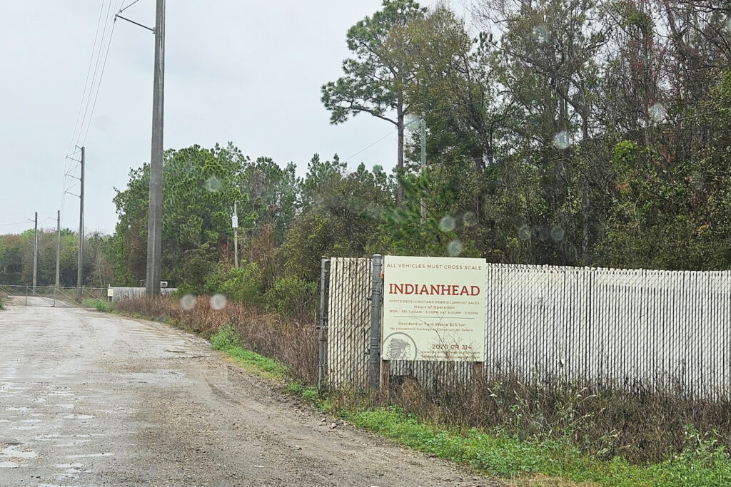 Indianhead Biomass sign on a dirt road on arainy day.