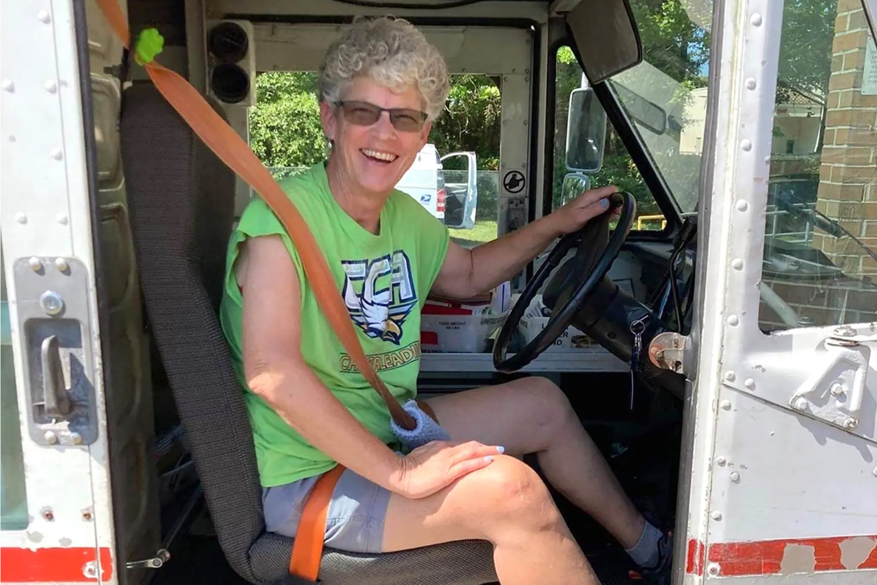 Woman wearing a seatbelt in a U.S. Postal carrier truck.