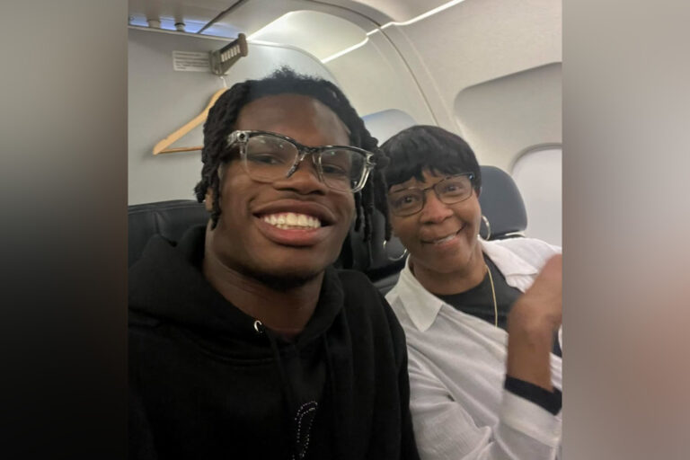 Travis Hunter smiles next to an older woman on an airplane.