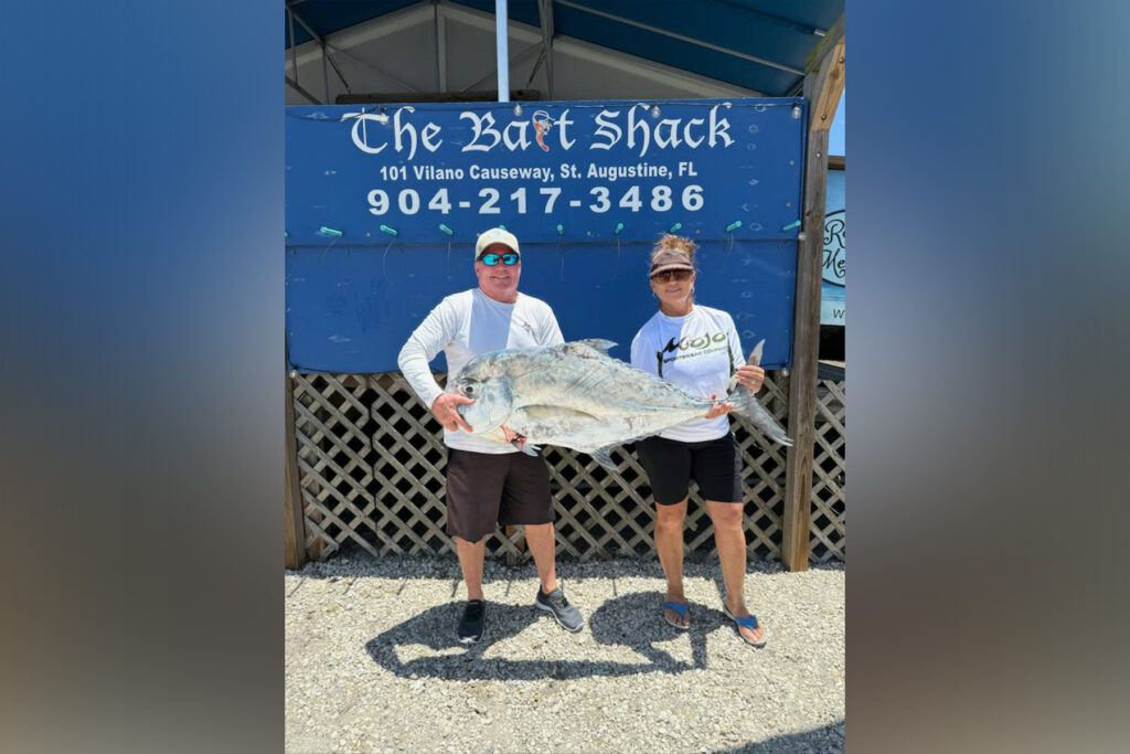 Two people holding large fish