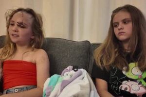 Two young girls sitting on a couch.